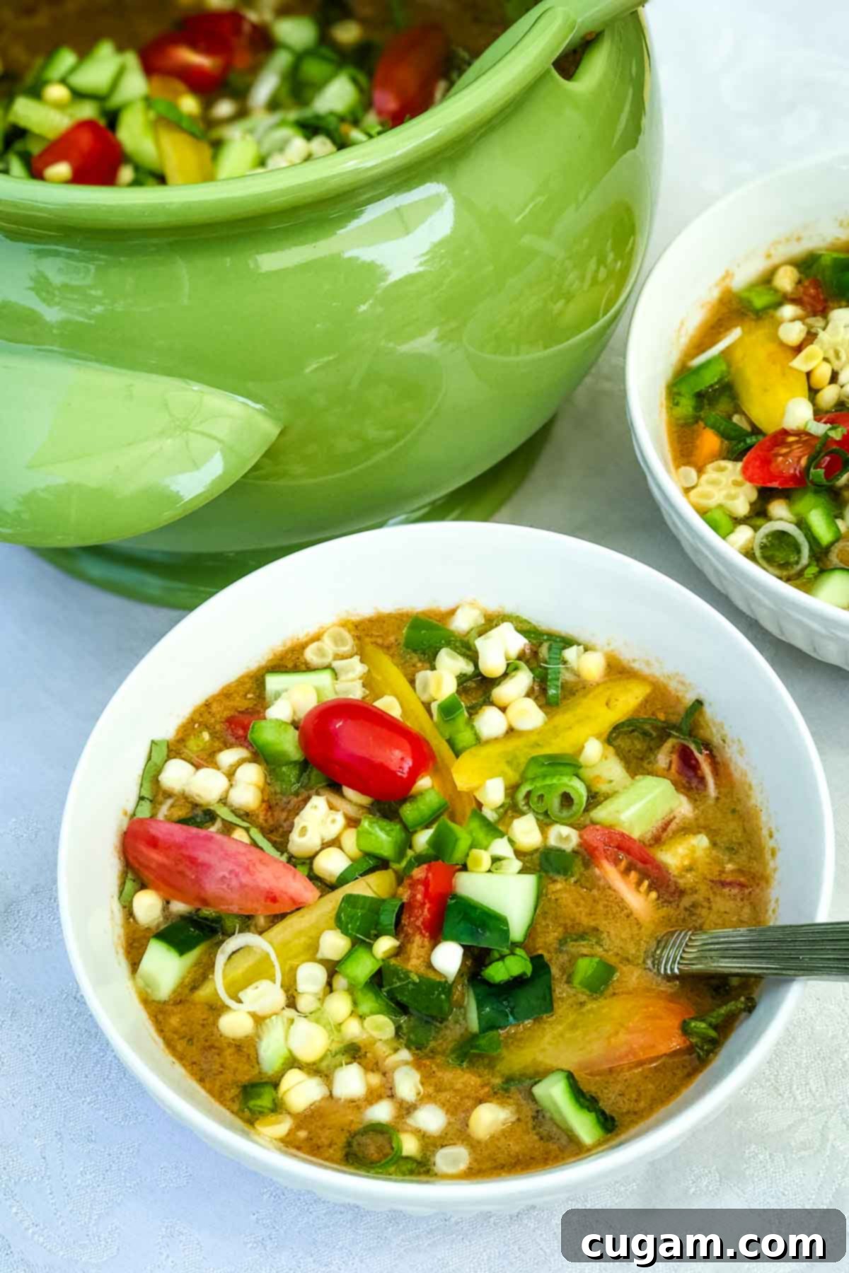 Bowl of fresh tomato gazpacho with chunky vegetables on top. 