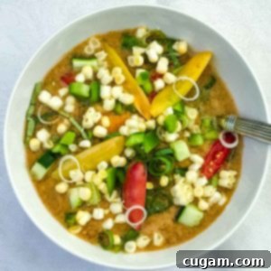 Chunks of vegetables floating on top of tomato gazpacho soup.