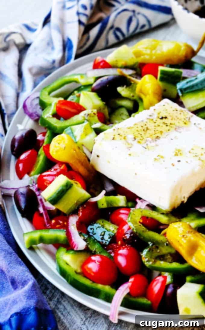 Authentic Horiatiki Salad presented on a white serving plate, showcasing vibrant tomatoes, cucumbers, and feta.
