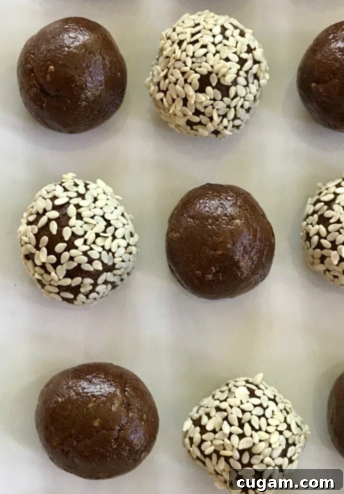 Close up of Halva Bliss Balls, some rolled in sesame seeds and others in pink freeze dried raspberry powder.