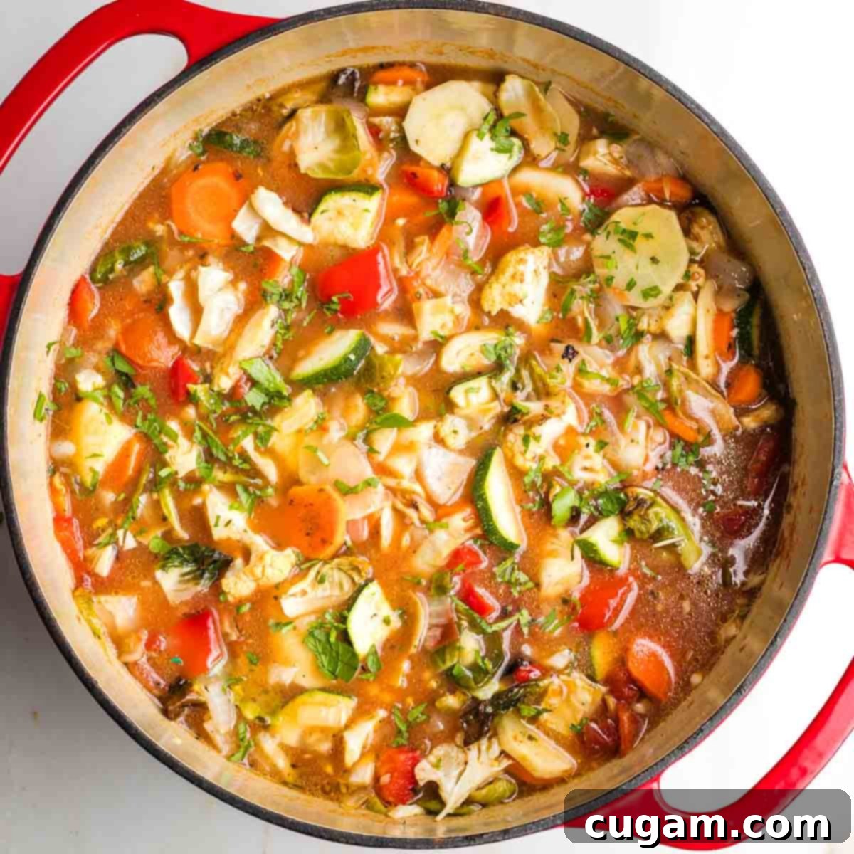 Dutch oven filled with chunky roasted vegetable soup, freshly combined.