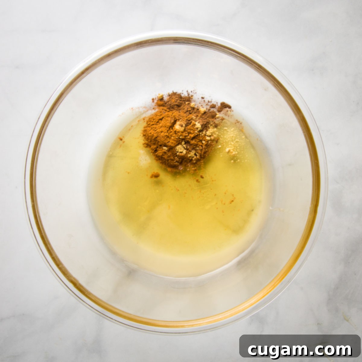 Spices, lemon juice and honey in a large glass bowl.