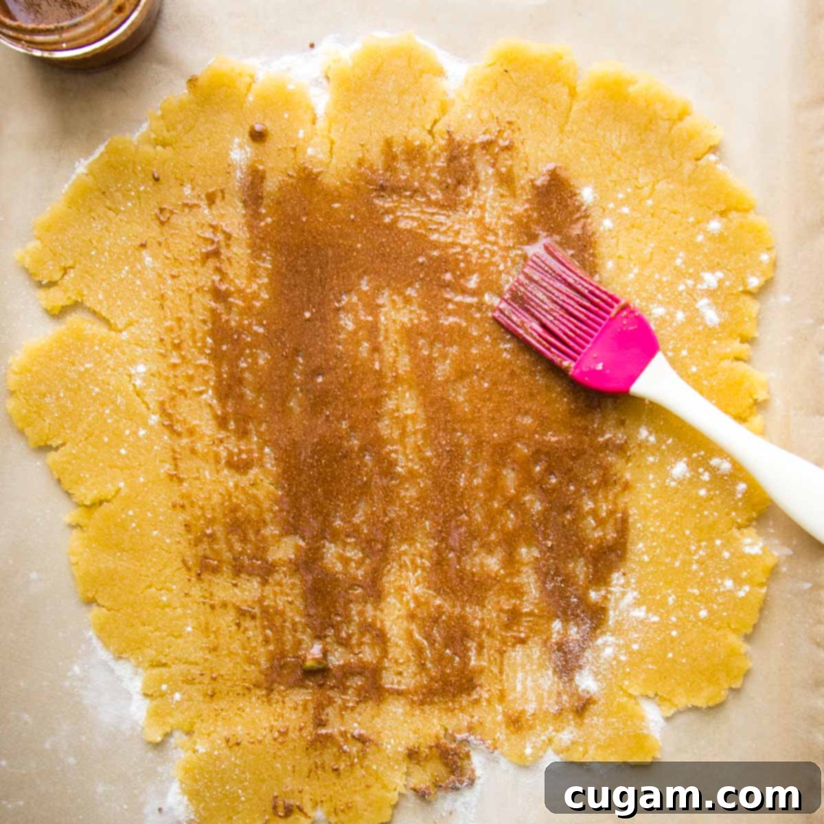 Galette dough rolled into a flat circle, sprinkled with arrowroot and then brushed with spice mixture.