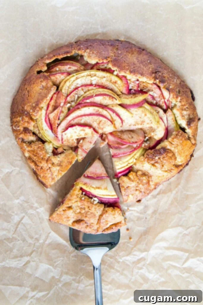 Apple galette with a slice on a serving piece.