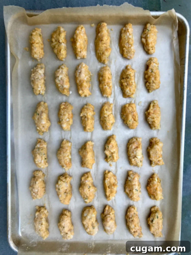 Guilt-Free Cauliflower Bites 4 Cauliflower and sweet potato tater tots lined up in rows, ready to bake.