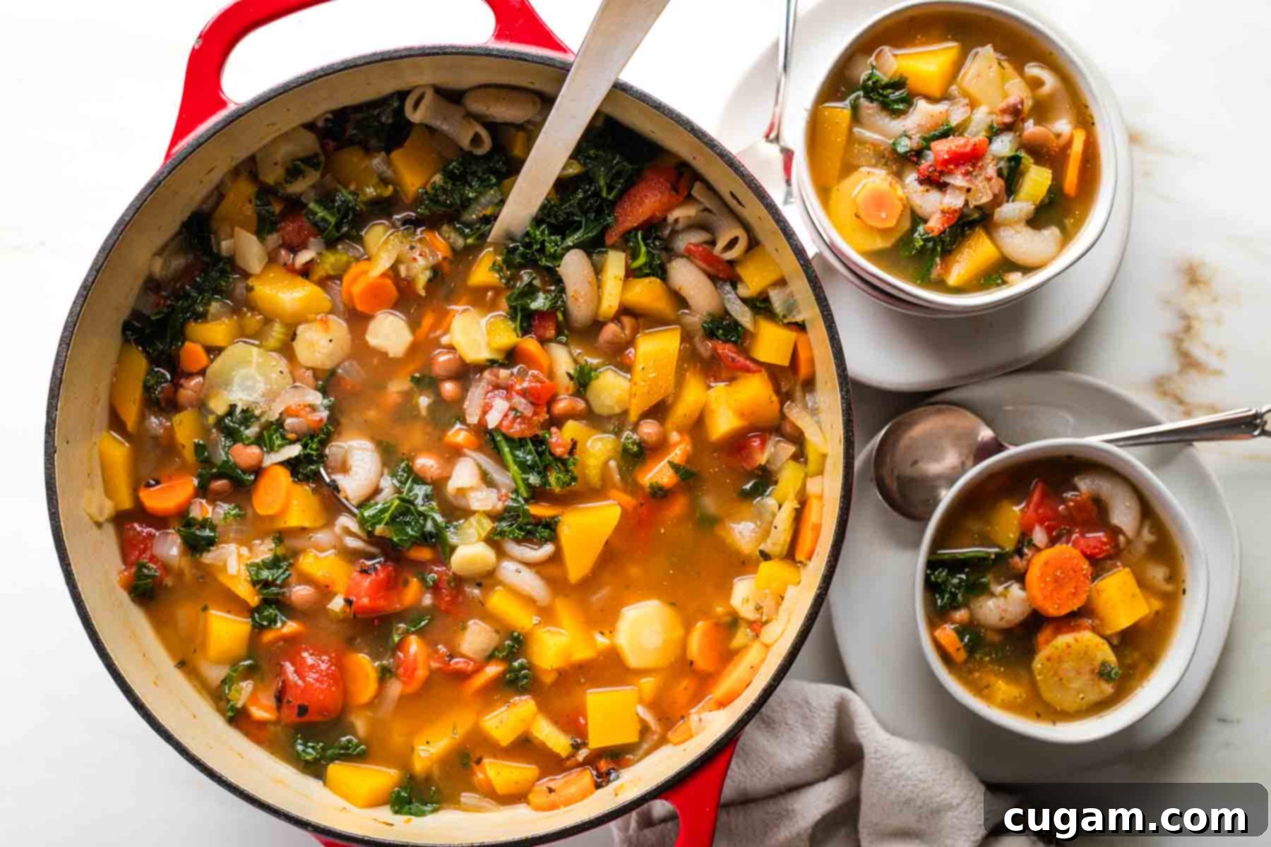 Ladling chunky minestrone soup from a dutch oven into bowls. 