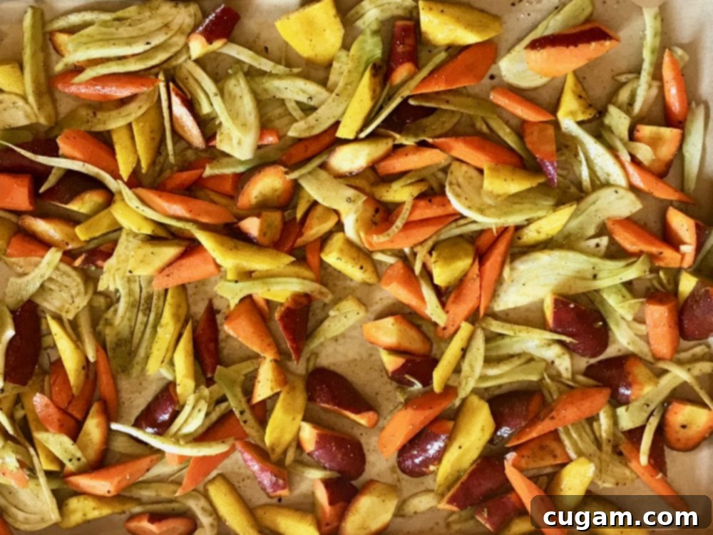Spiced carrots and fennel pieces on a baking sheet, ready for roasting to enhance their flavor and nutrition in the salad