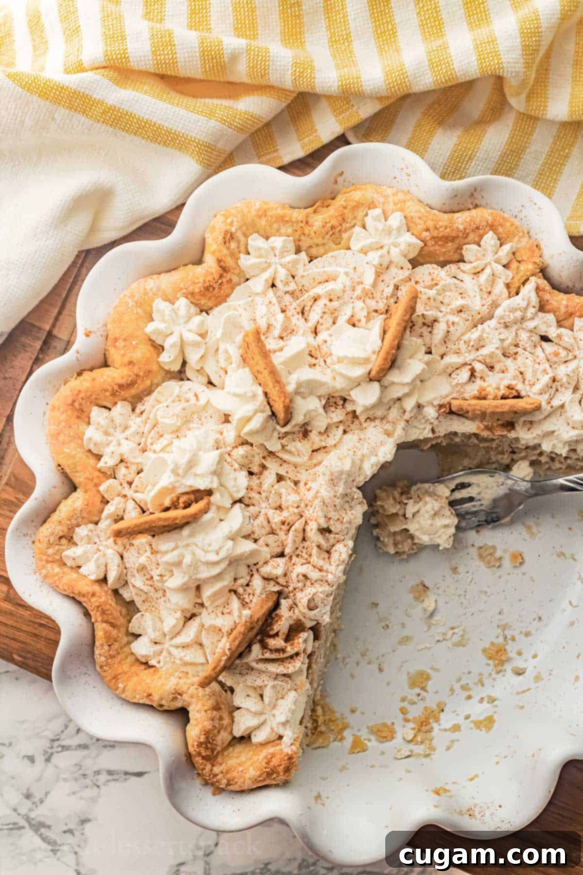 Baked banana pie with slices removed from white pan with bite of pie on fork resting in pie pan.
