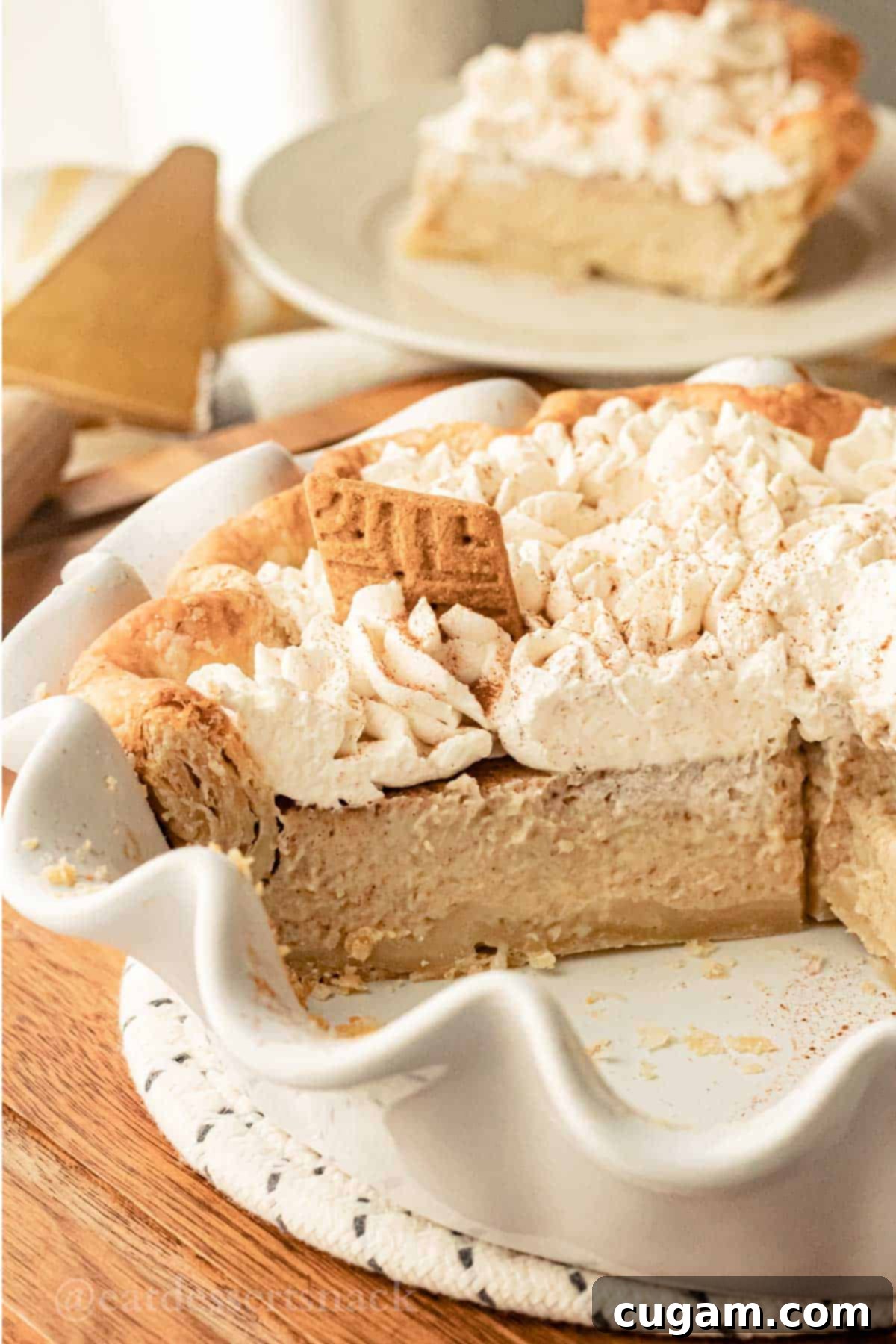 Slice of banana cream pie in white fluted pie pan.