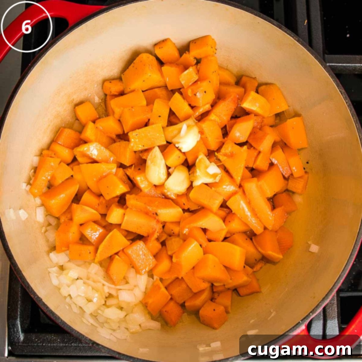 Roasted butternut squash cubes, with garlic and onions in a dutch oven.