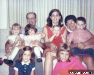 A heartwarming family photo from Thanksgiving, showing young children dressed for the holiday alongside their grandparents. The author, a young child, is seated on her grandfather's lap.