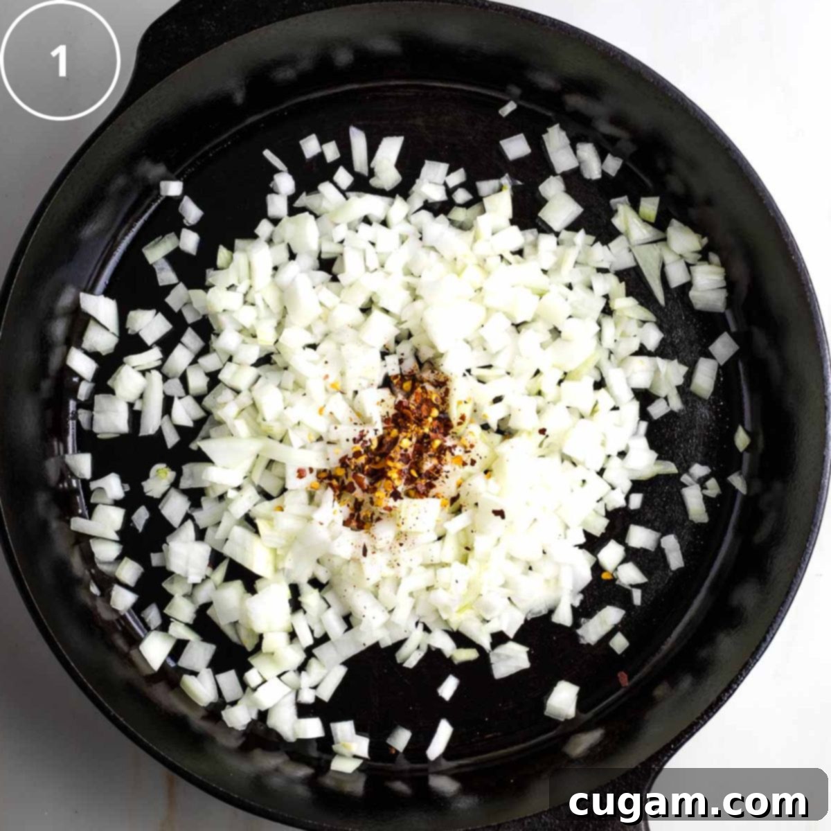 Vibrant Mediterranean Cauliflower Rice 4 Step 1: Cast iron skillet with diced onions and crushed red pepper.