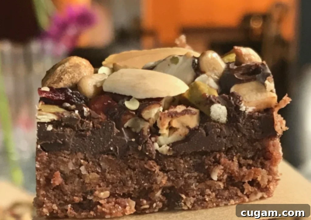 A wider shot of several chocolate oatmeal trail bars arranged on a wooden cutting board, with some already cut into individual portions.