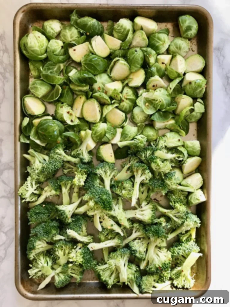 A tray of broccoli and brussels sprouts, ready to roast. 