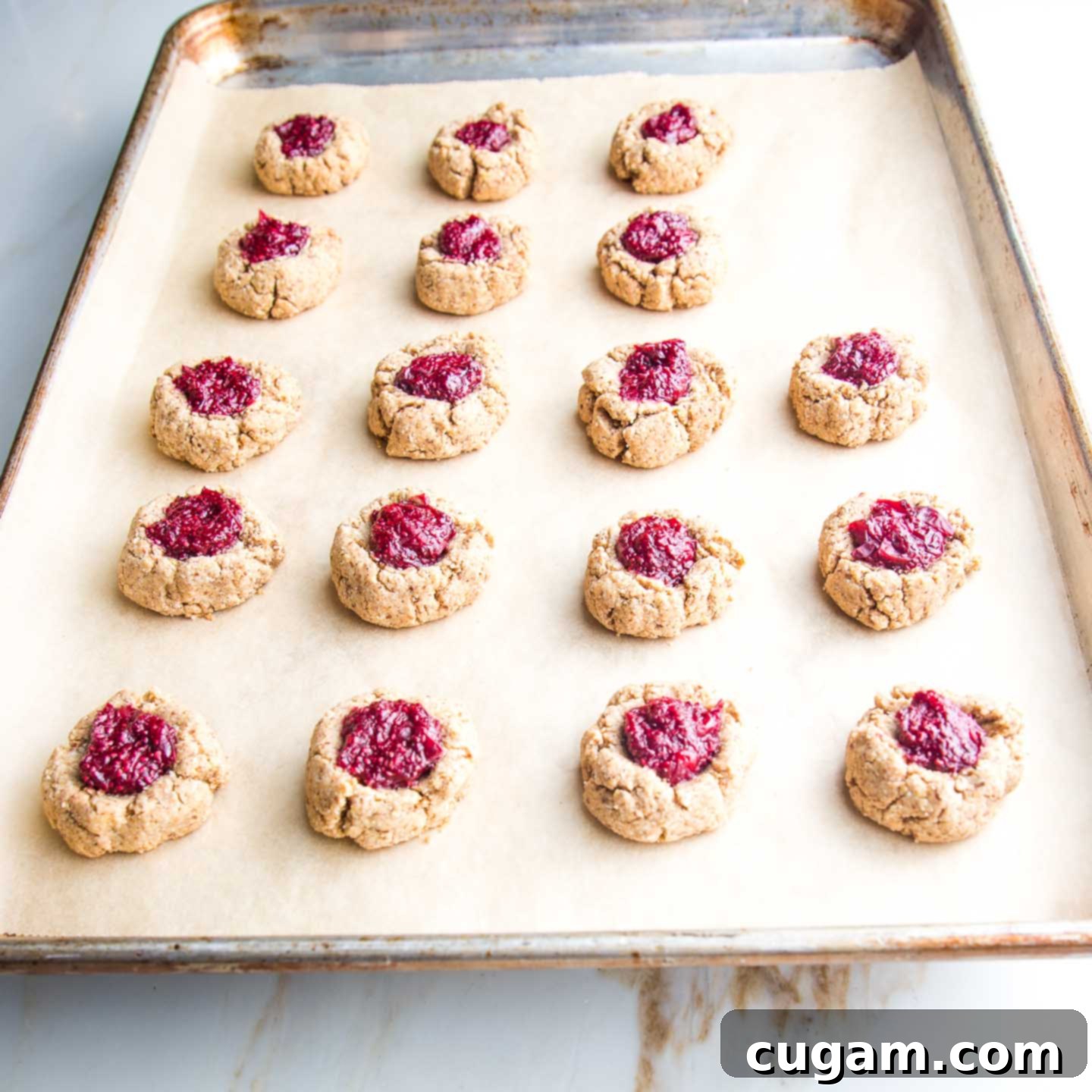 Tray of Thumbprint cookies filled with cranberry chia jam, freshly baked.