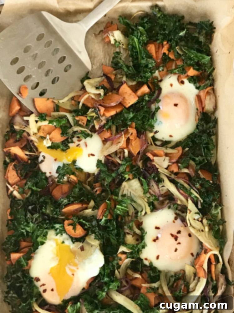 Veggie hash with sweet potatoes, kale and onions with eggs nestled inside.
