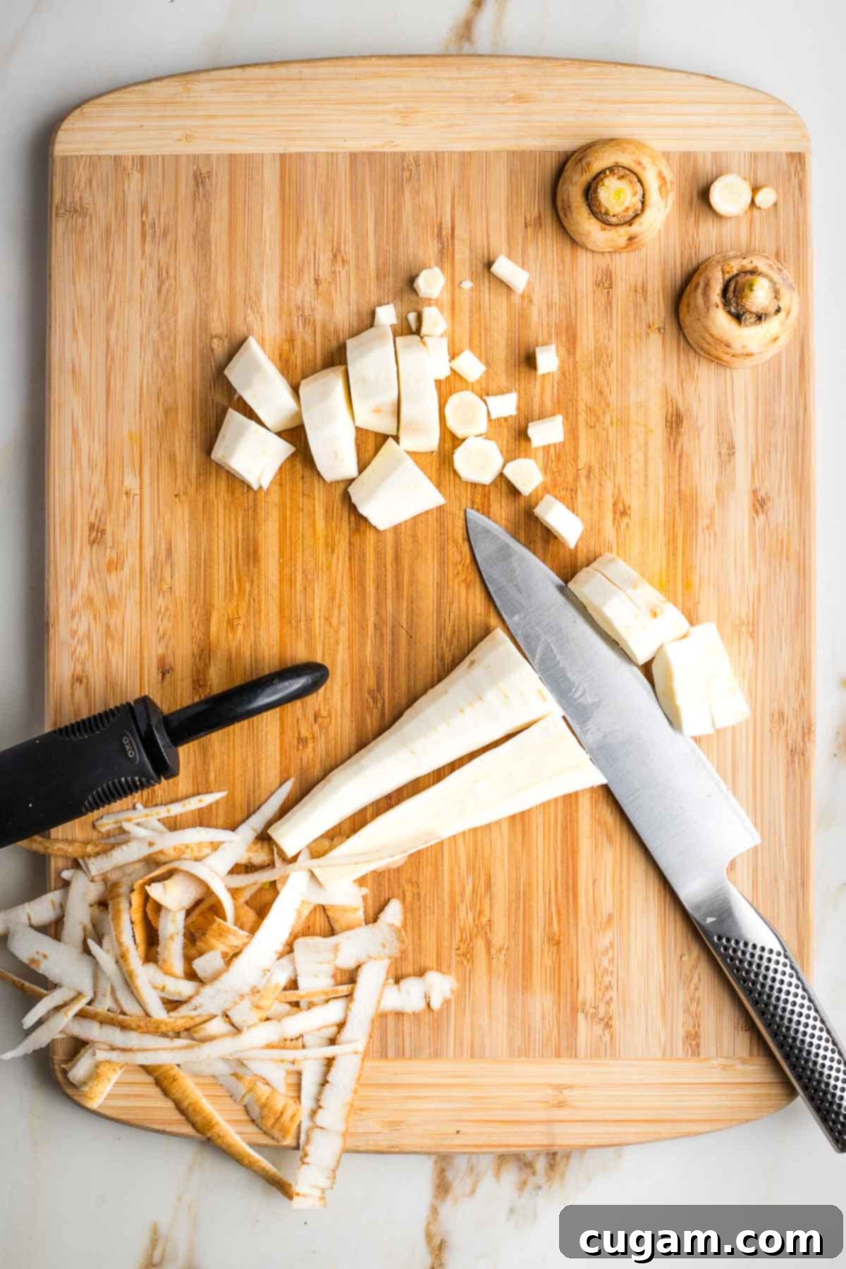 Parsnips on a cutting board, peeled and trimmed. 
