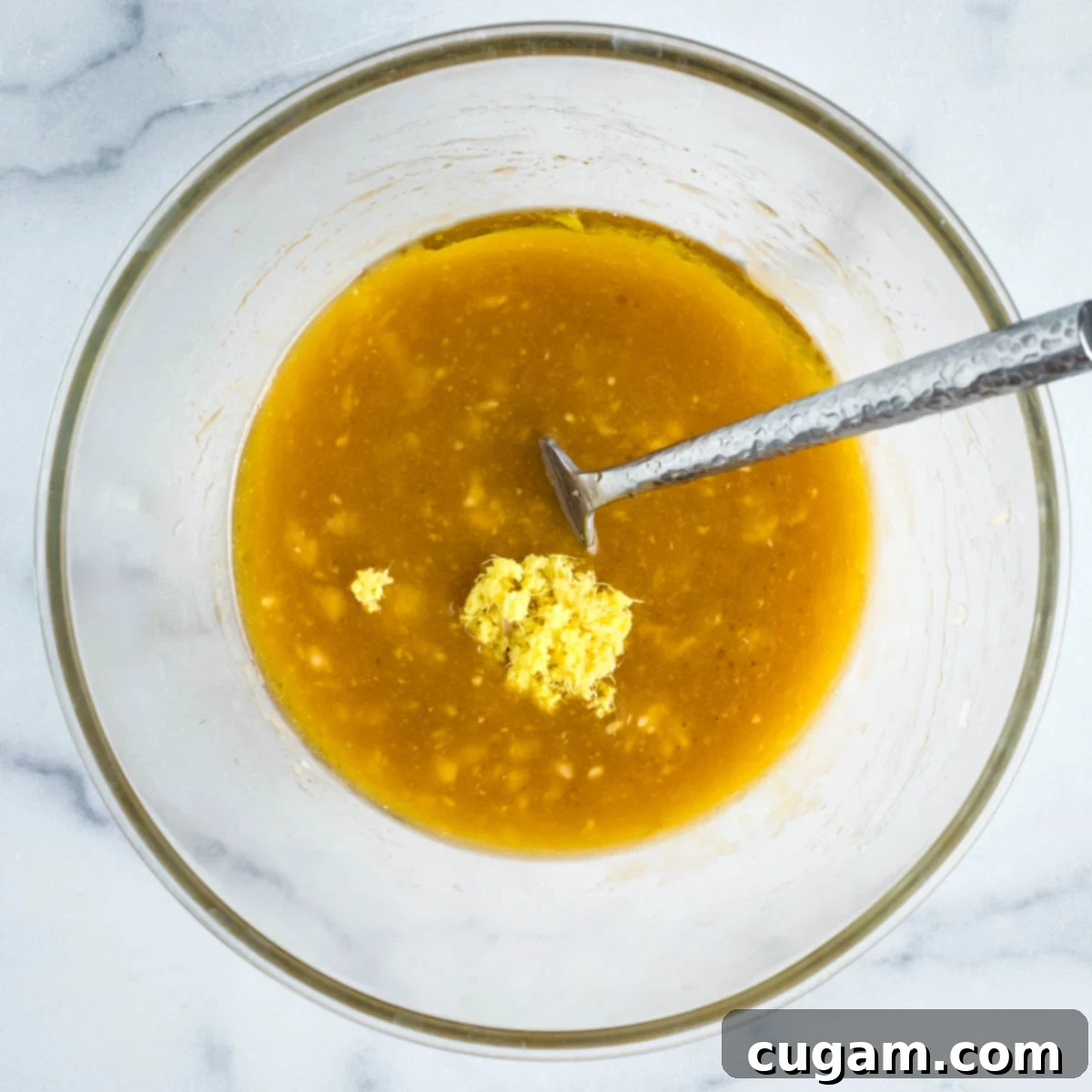 Adding grated ginger to the banana mixture.