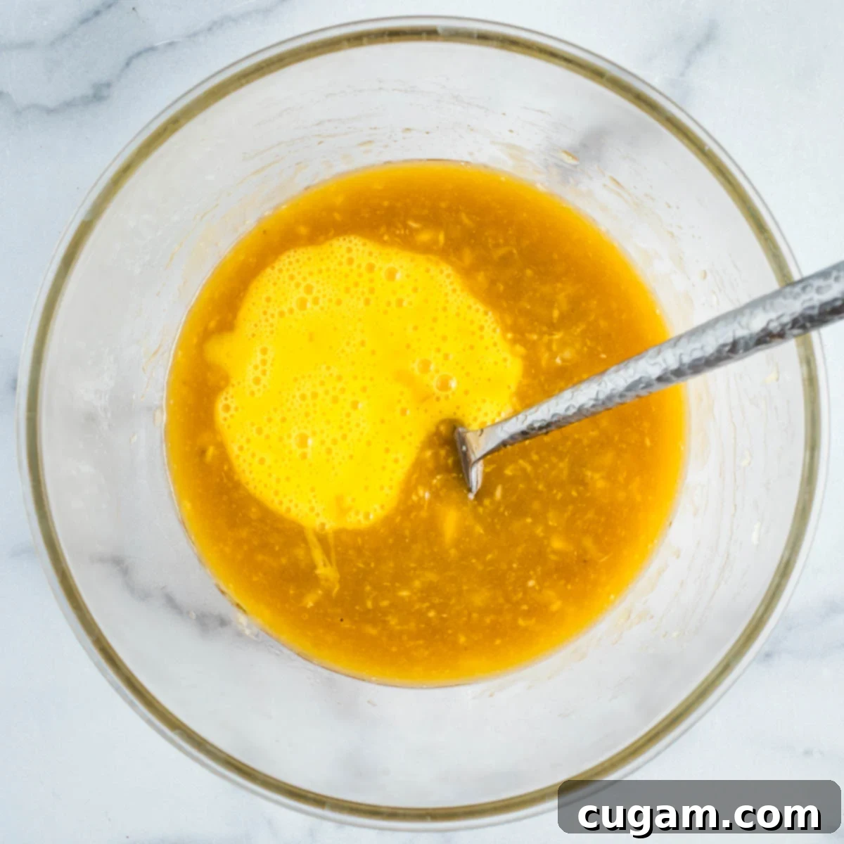 Whisked eggs being poured into the wet ingredients.