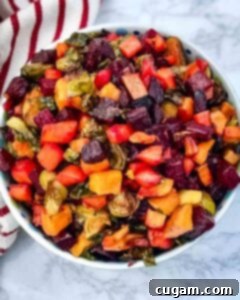 Bowl of roasted, cubed veggies like beets, brussels sprouts, carrots and sweet potatoes.