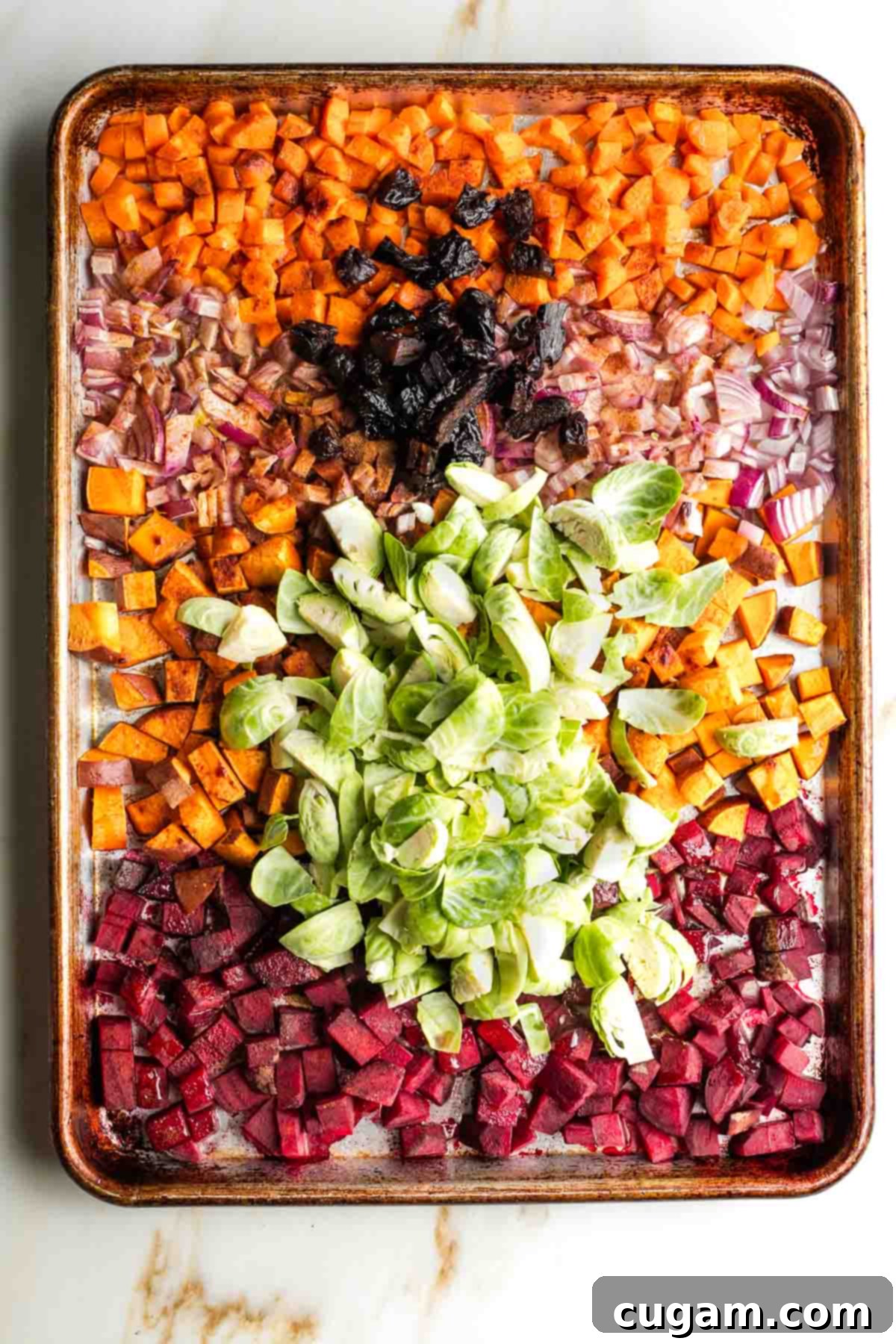 The initial roasted vegetable mixture, now with cinnamon, salt, pepper, Brussels sprouts, and prunes added.