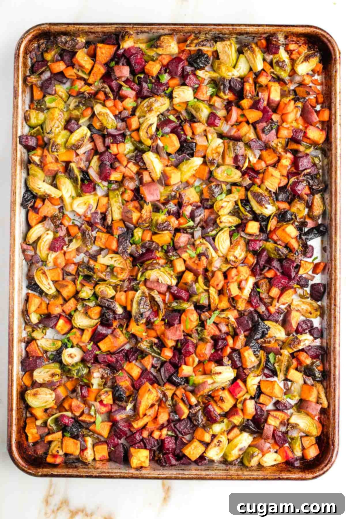 The fully roasted tzimmes in a bowl with a spatula, ready to be served.