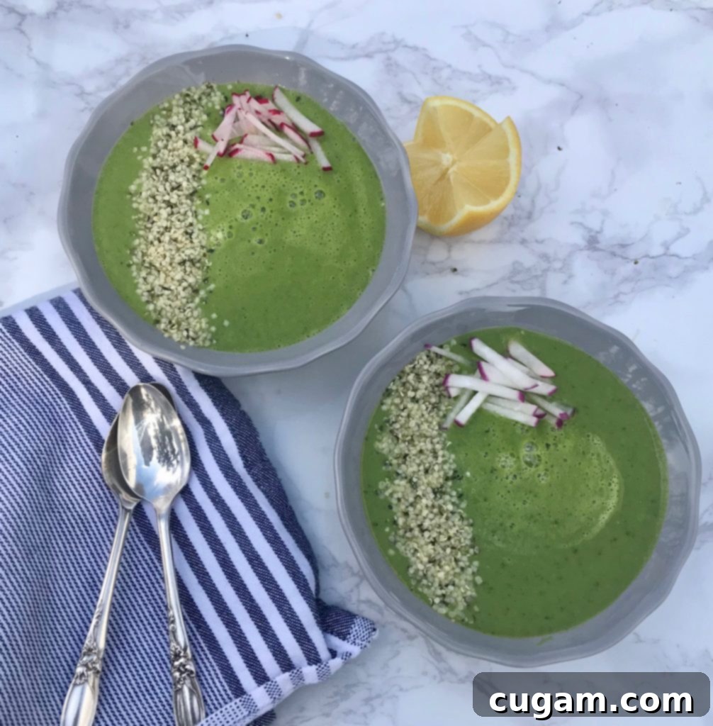 A beautifully bright green Spring Greens Soup in a bowl, garnished with fresh herbs and a drizzle of olive oil.