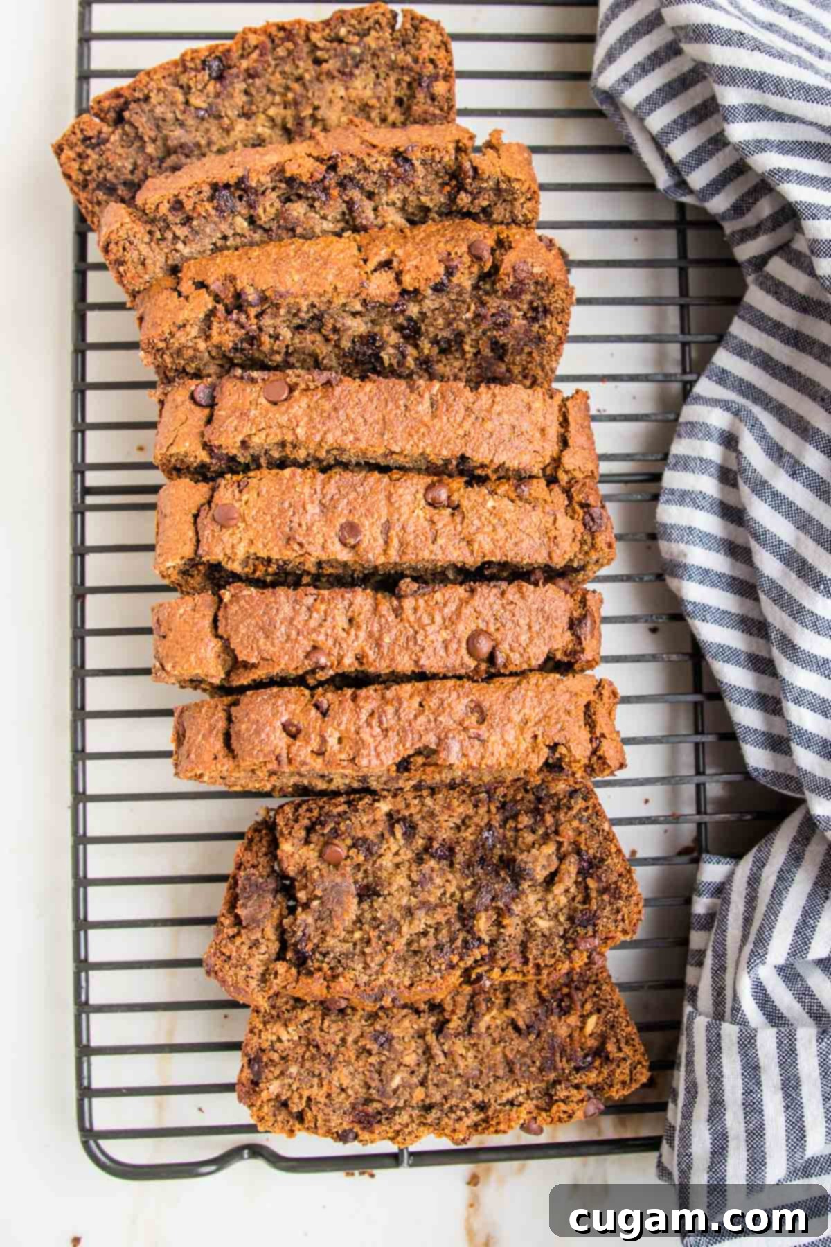 Banana bread with chocolate chips cut into thick slices on a wire rack. 