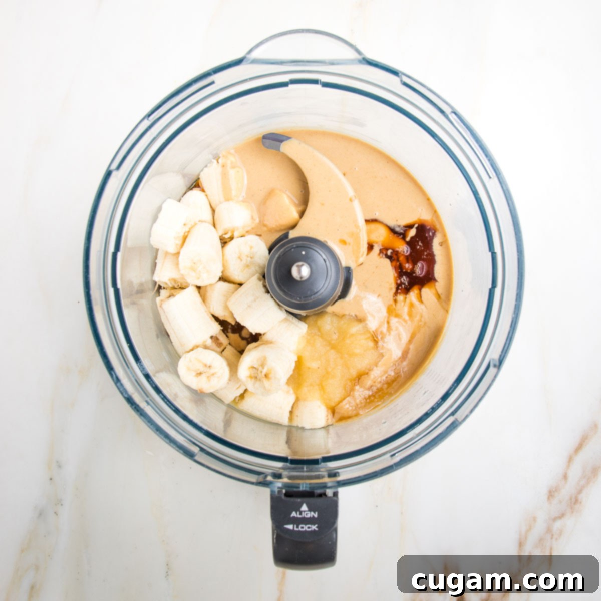 Food processor bowl with bananas, tahini, applesauce and maple syrup to make banana bread