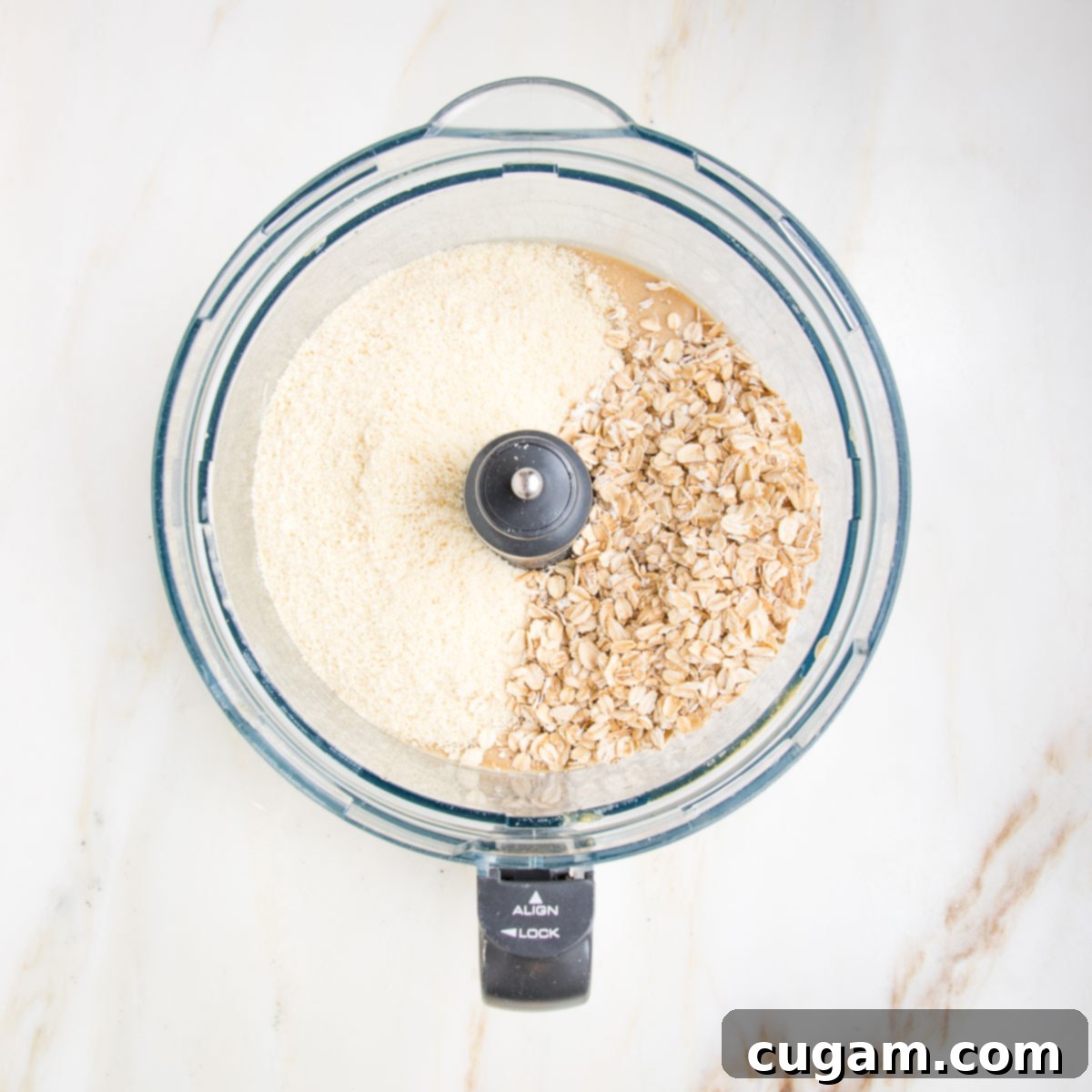 Food processor bowl with almond flour and oats visible. 
