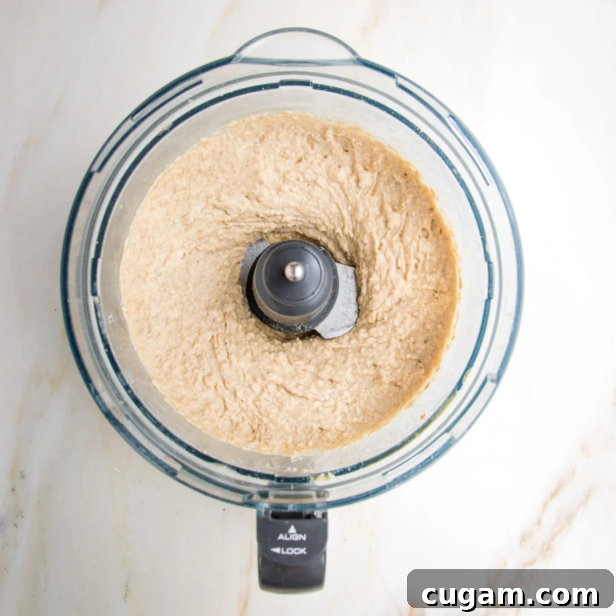 thick and creamy beige colored banana bread batter in a food processor bowl