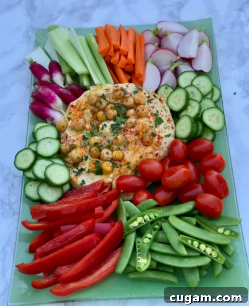 A bowl of creamy, healthy hummus topped with a sprinkle of paprika and fresh parsley.