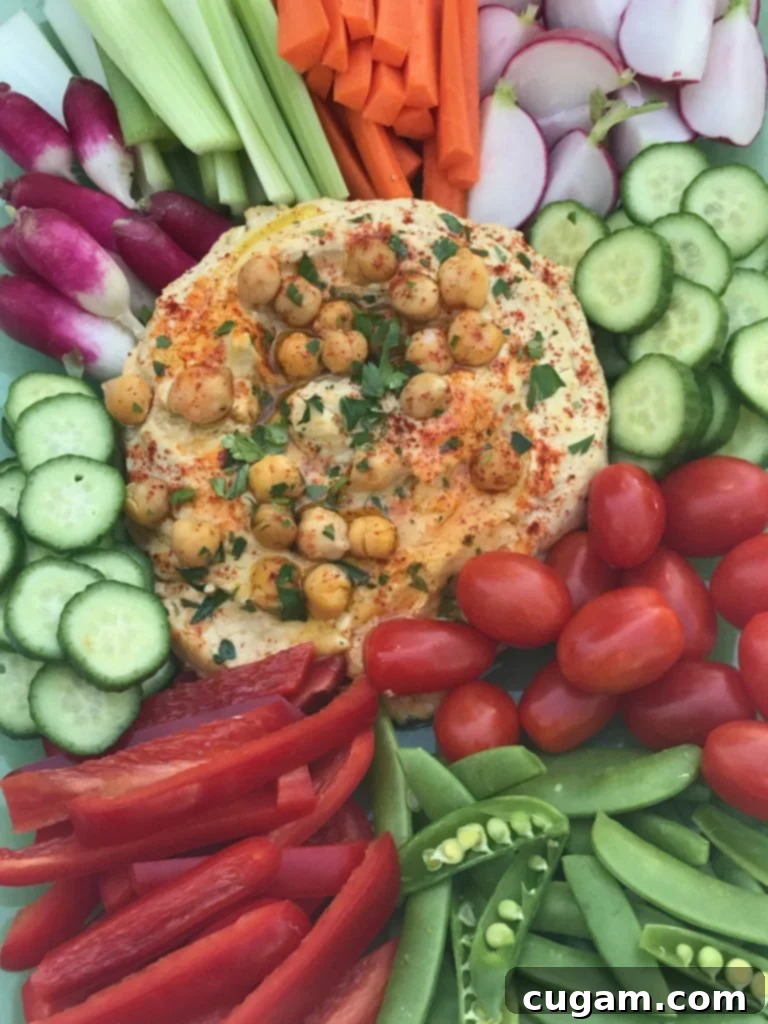 A serving of healthy hummus garnished with a sprig of fresh herbs, ready for dipping or spreading.