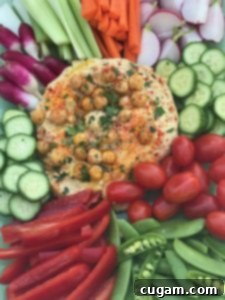 Hummus surrounded by colorful veggies.