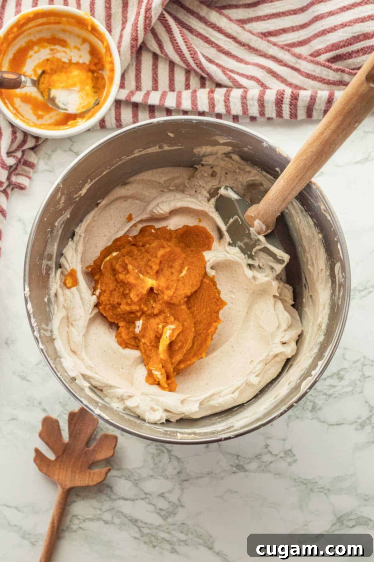 Irresistible Pumpkin Cream Cheese Dip 8 Smooth pumpkin puree being gently folded into the spiced whipped cream cheese mixture using a rubber spatula, ensuring a delicate and even blend.