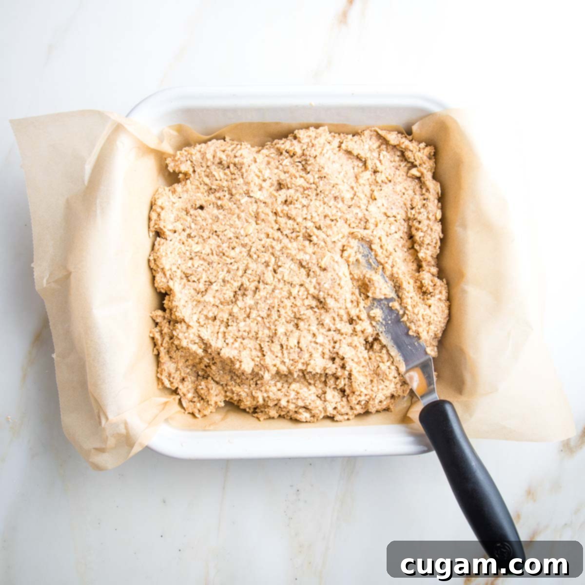 Batter dumped into a square baking pan, ready to be spread.