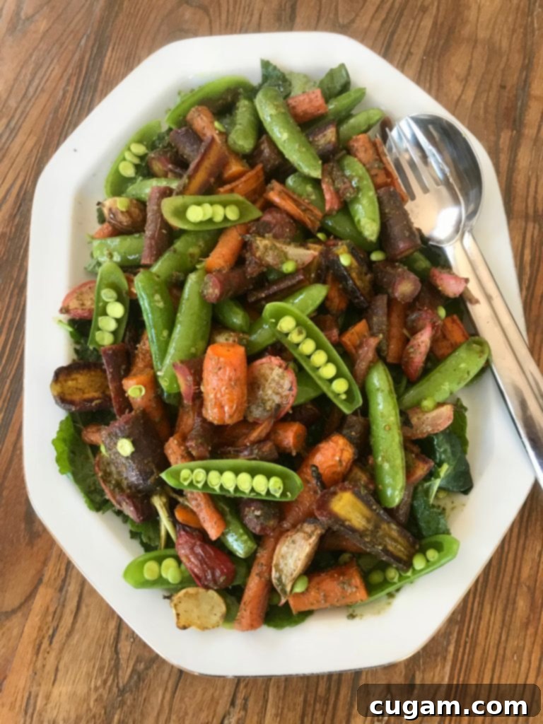 Roasted and raw vegetables tossed with carrot top pesto, beautifully served on a bed of fresh baby kale for a complete, vibrant salad.