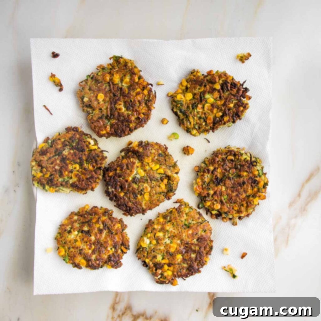 Crispy fritters draining on a paper towel.