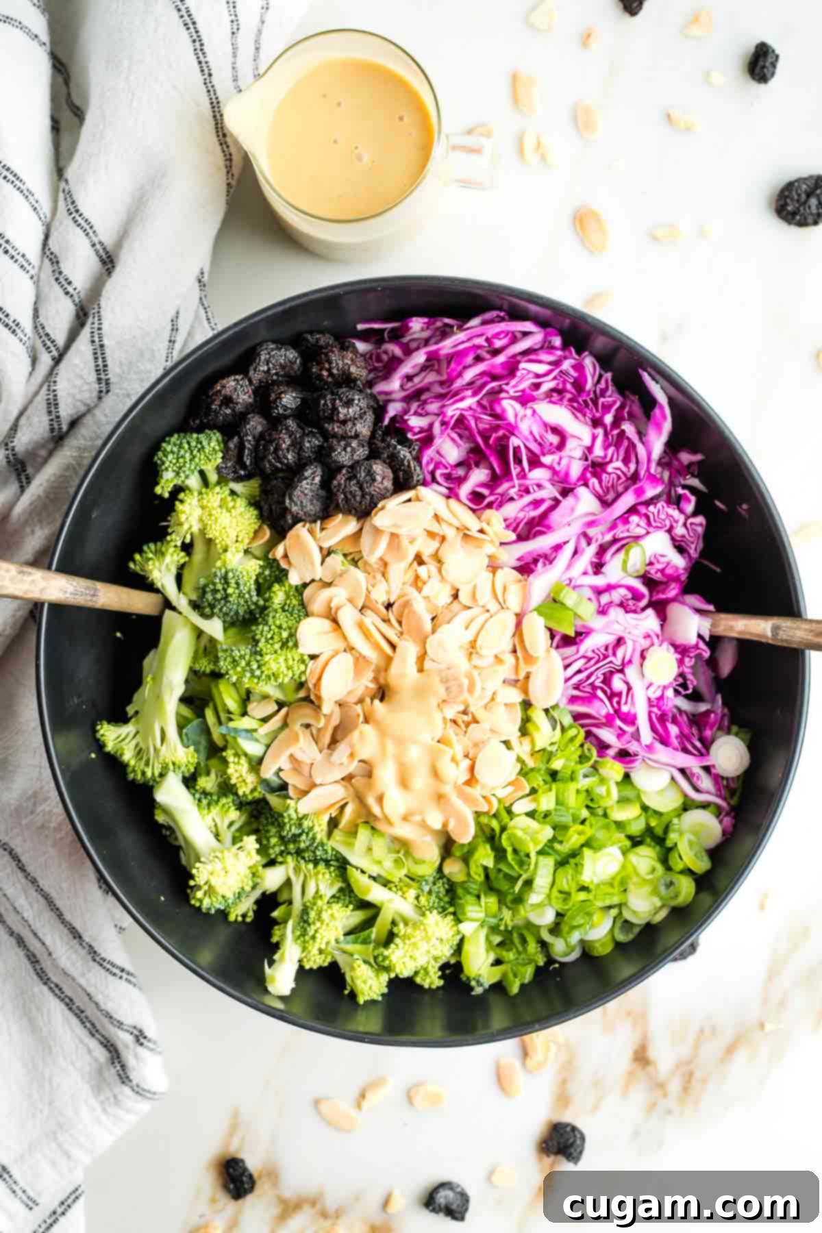 Crisp Raw Broccoli Salad with Miso Dressing 12 Dressing in the center of a prepped salad with broccoli, cabbage, nuts, dried fruit and scallions.