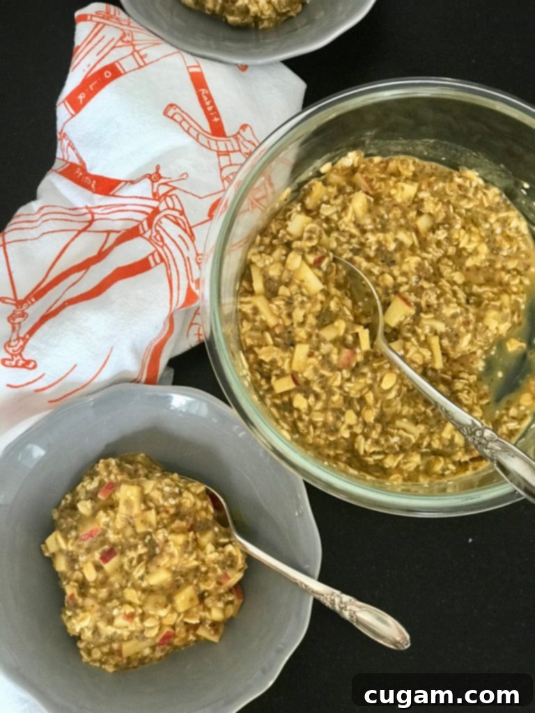 Autumn Spiced Overnight Oats 5 A spoon digging into a jar of pumpkin overnight oats, showing its creamy texture, with a healthy topping.