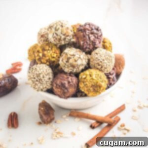White bowl with pumpkin energy balls stacked up. They are coated with different nuts and seeds. In the foreground are dates, oats, cinnamon sticks and whole pecans.