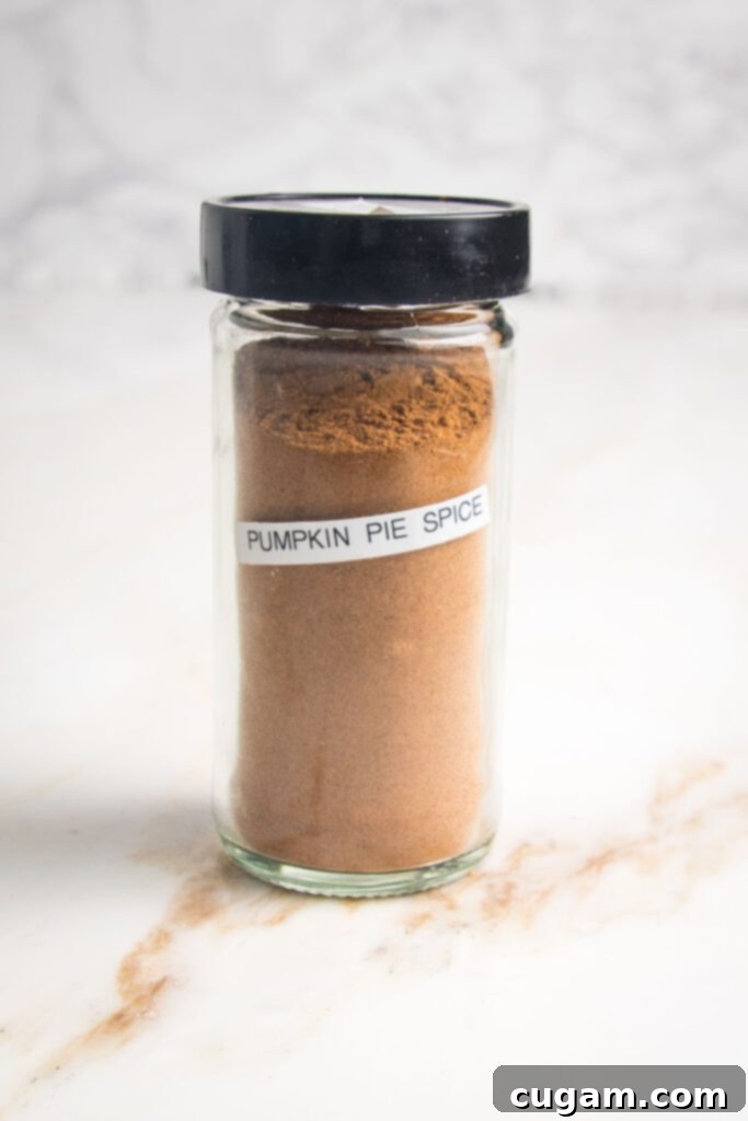 Small jar with black lid filled with brownish spice with a label on the jar that says, "Pumpkin Pie Spice"