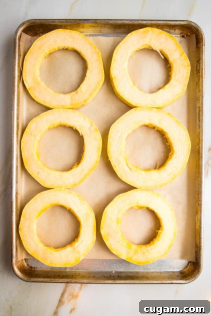 Spaghetti squash rings on a parchment-lined baking tray.
