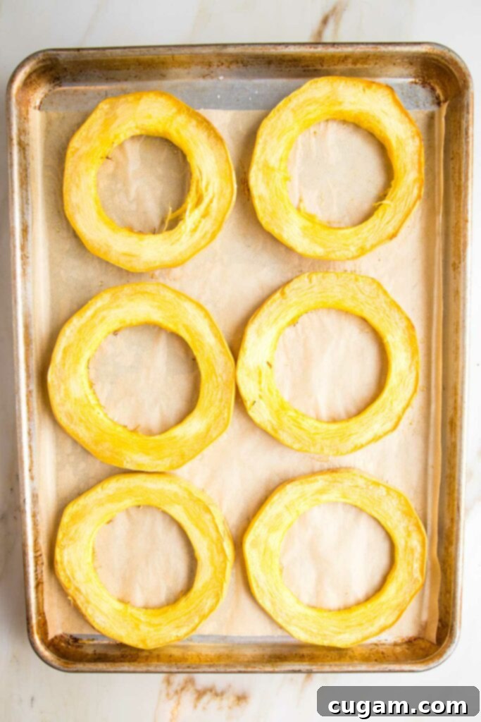 Roasted spaghetti squash rings on a parchment-lined baking tray.