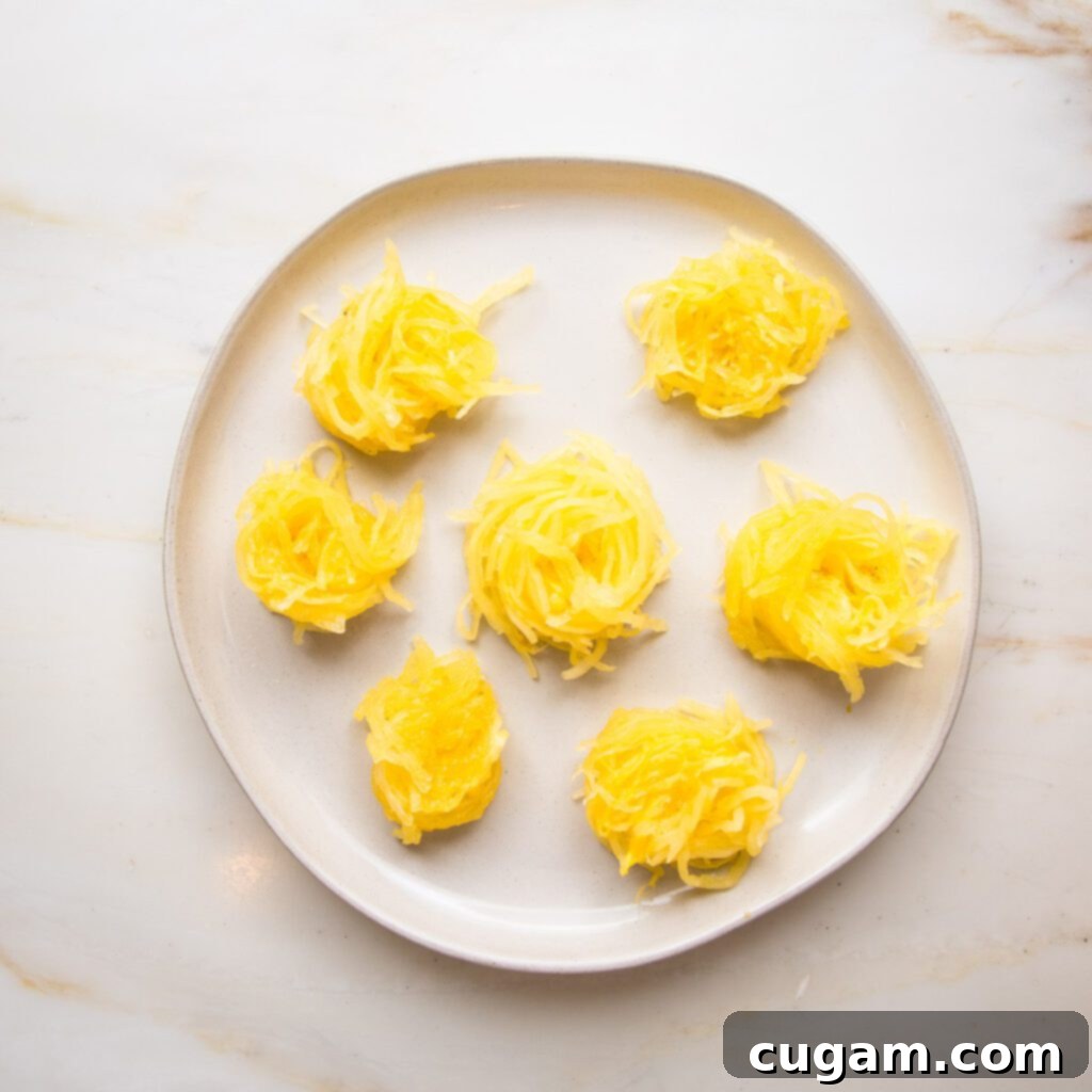 White rimmed plate with twirled sections of spaghetti squash.