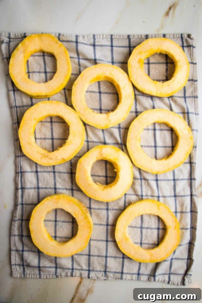 Spaghetti squash rings sprinkled with kosher salt on a kitchen towel.