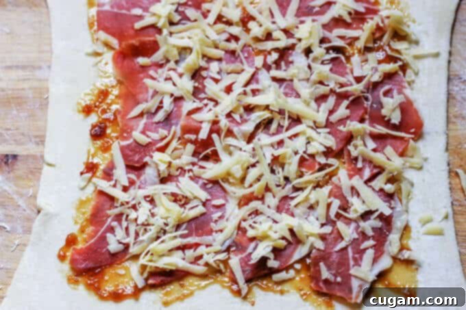 Adding shredded Cured Mahon-Menorca cheese over the Serrano ham.