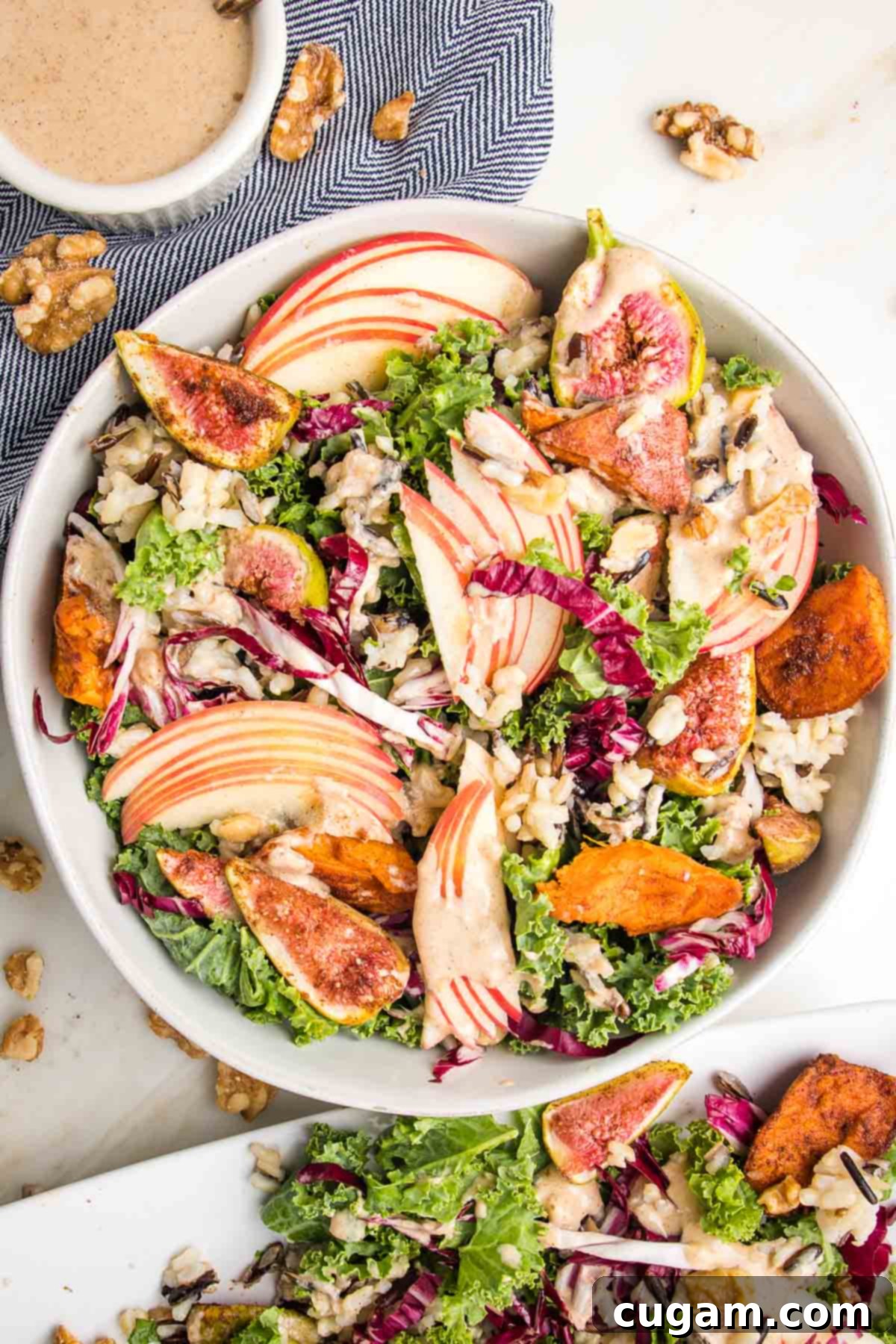 Bowl of salad with sliced apples, figs, sweet potatoes, radicchio and creamy dressing.