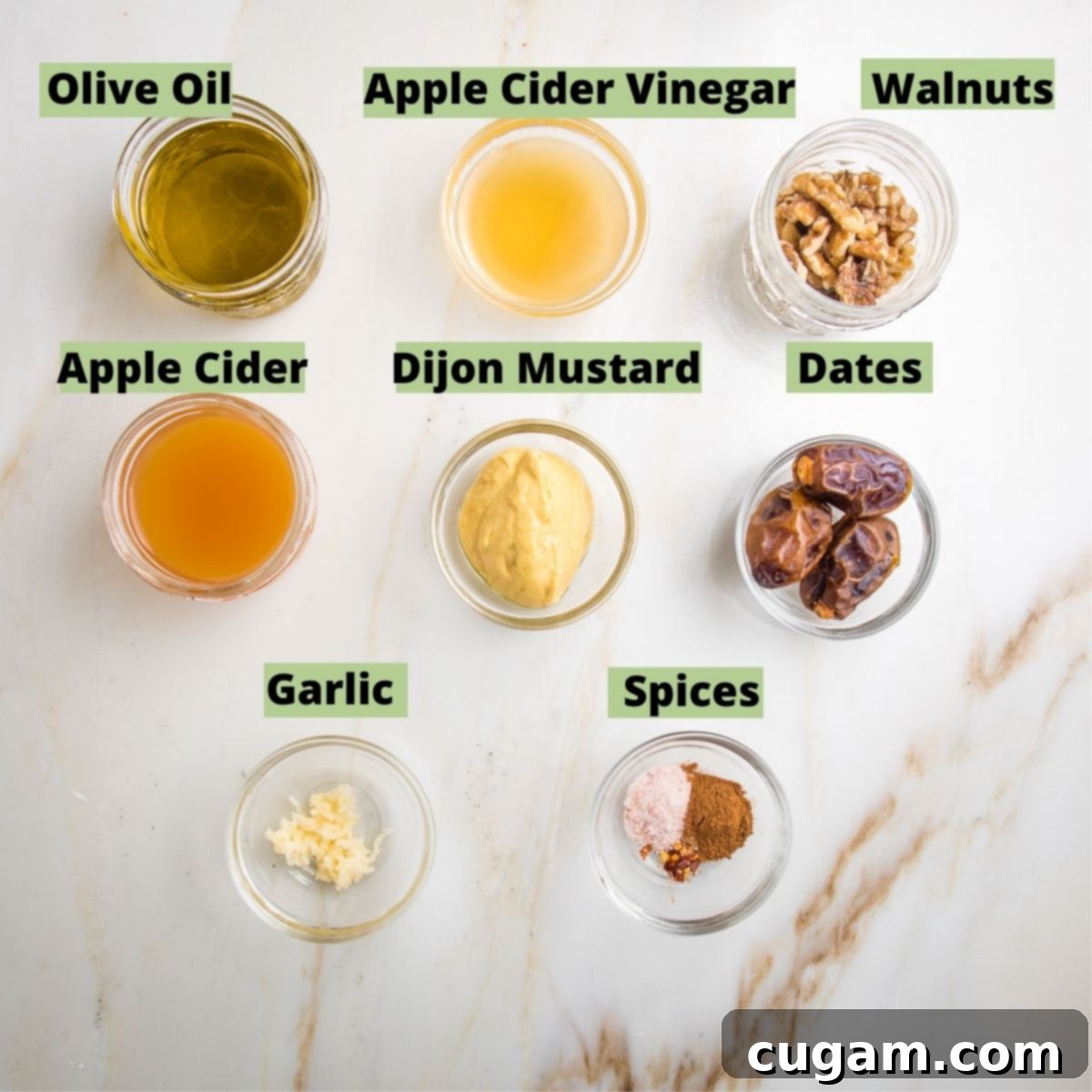 Labeled ingredients for a creamy apple vinaigrette: Olive oil, apple cider vinegar, walnuts, apple cider, dijon mustard, dates, garlic, spices.