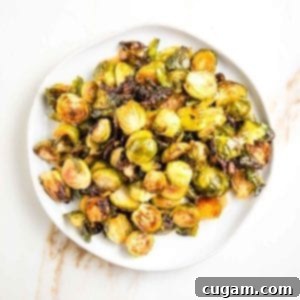 Round plate filled with roasted brussels sprouts with sweet and spicy drizzle